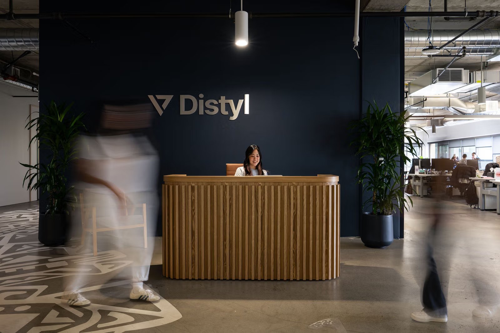 Distyl's front desk, with two people blurring past in motion