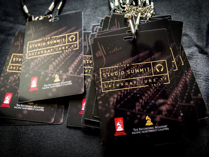 Stacks of black and gold PNW Studio Summit lanyard badges for the Recording Academy